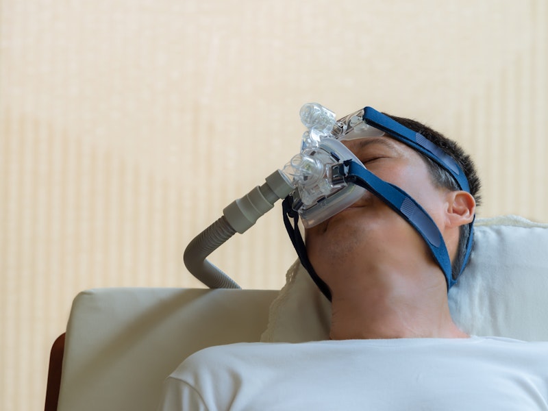 Man sleeping while wearing a CPAP machine